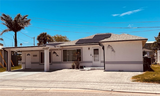 view of front of property featuring a carport and solar panels