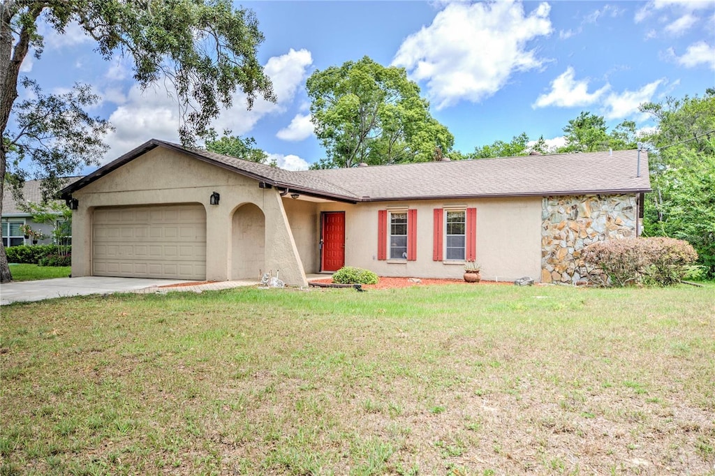 single story home with a garage and a front lawn