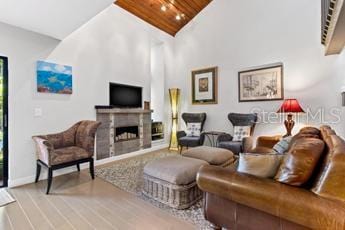 living room with a fireplace, high vaulted ceiling, hardwood / wood-style floors, and wood ceiling