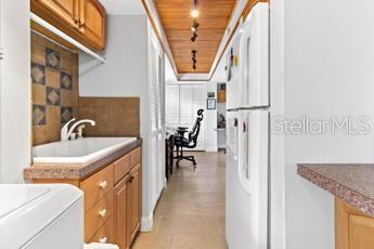 kitchen featuring sink, white fridge, and wood ceiling