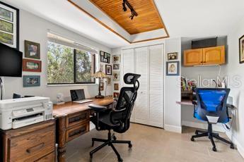 home office featuring a tray ceiling and track lighting