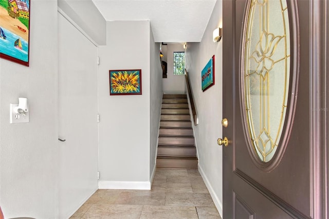 tiled entryway with a textured ceiling