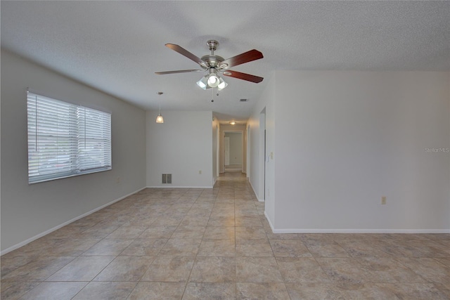 tiled spare room with ceiling fan and a textured ceiling