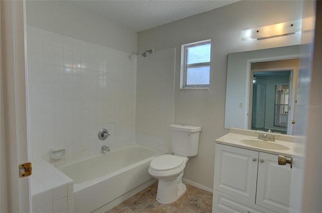 full bathroom featuring tiled shower / bath, tile flooring, vanity with extensive cabinet space, and toilet