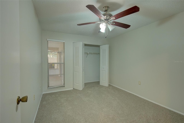 unfurnished bedroom featuring a textured ceiling, a closet, carpet, and ceiling fan