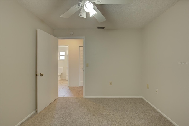 carpeted spare room with a textured ceiling and ceiling fan