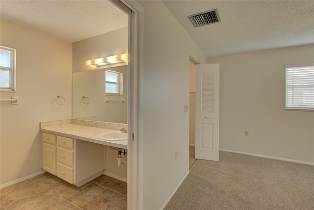 bathroom with vanity, a textured ceiling, and tile floors