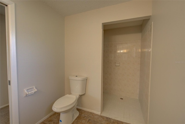 bathroom featuring tile flooring, a textured ceiling, and toilet