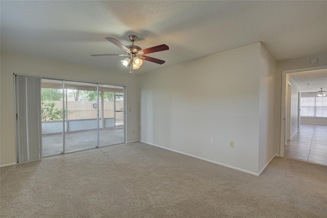 spare room featuring carpet, ceiling fan, and a textured ceiling