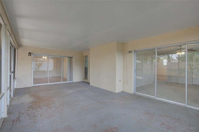 unfurnished sunroom featuring ceiling fan