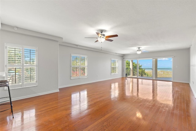 unfurnished room featuring ceiling fan, a healthy amount of sunlight, and wood-type flooring