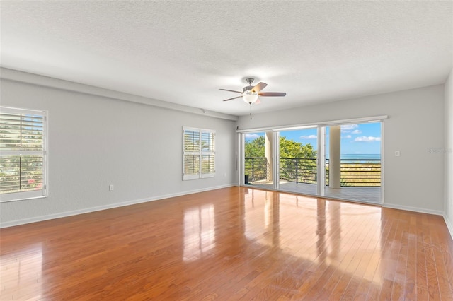 spare room featuring wood-type flooring, ceiling fan, and a textured ceiling