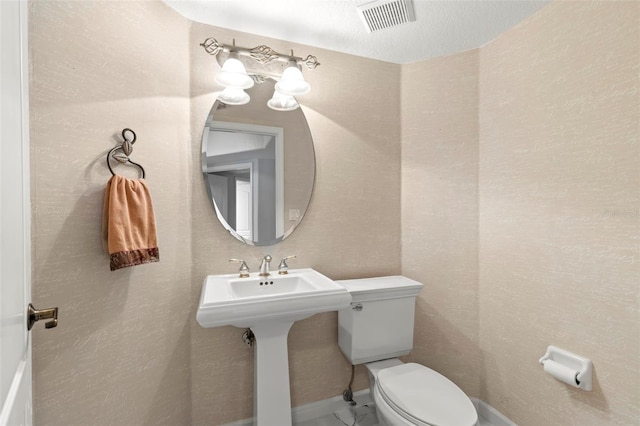 bathroom with tile floors, toilet, and a textured ceiling