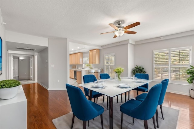 dining space featuring plenty of natural light, ceiling fan, light hardwood / wood-style flooring, and a textured ceiling