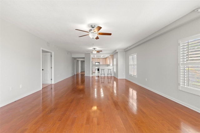 unfurnished living room with ceiling fan and hardwood / wood-style flooring