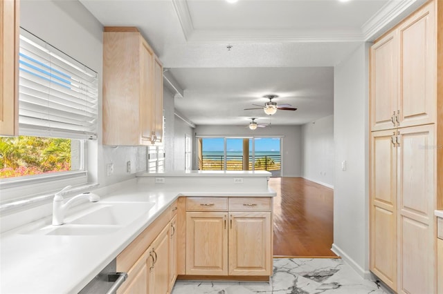 kitchen with ceiling fan, kitchen peninsula, light brown cabinetry, light tile floors, and sink