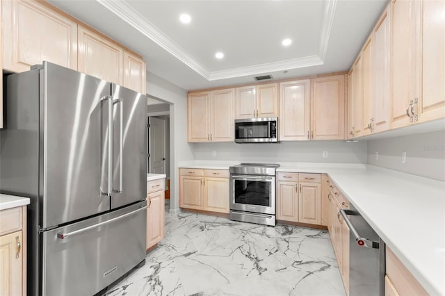 kitchen with appliances with stainless steel finishes, a tray ceiling, and light brown cabinets