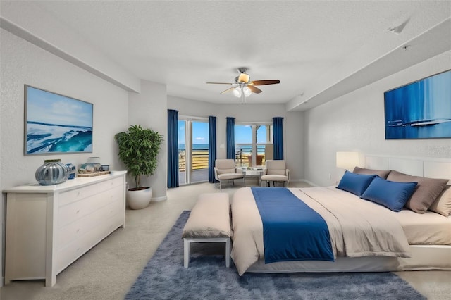 carpeted bedroom with ceiling fan and a textured ceiling