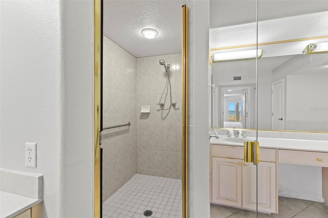 bathroom with a shower with door, tile flooring, oversized vanity, and a textured ceiling