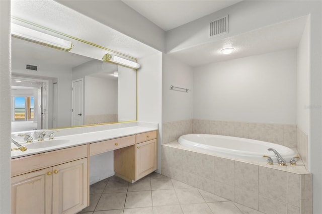 bathroom featuring tile flooring, tiled bath, and vanity