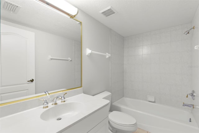 full bathroom with tiled shower / bath, a textured ceiling, toilet, and vanity