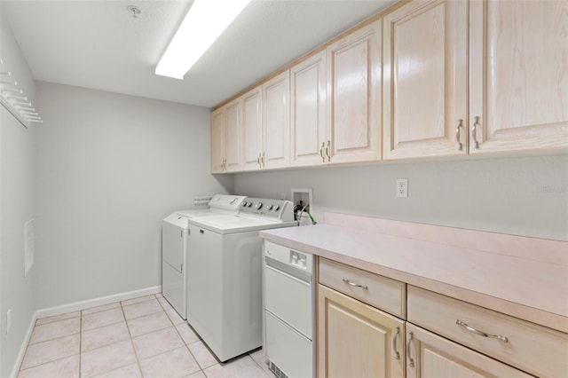 clothes washing area featuring hookup for a washing machine, separate washer and dryer, cabinets, and light tile floors