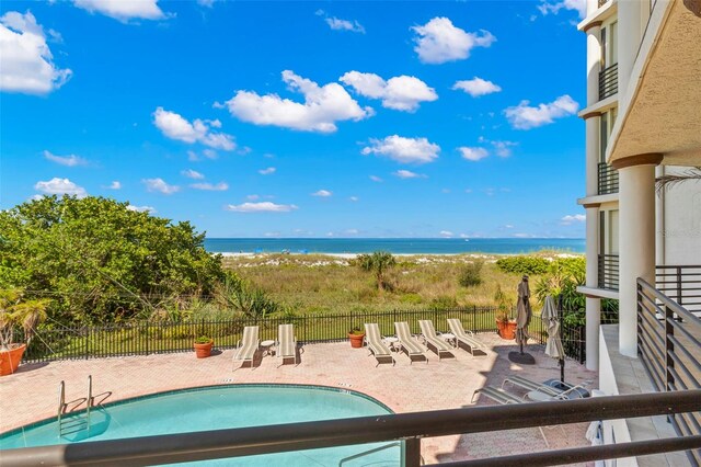 view of pool with a patio and a water view