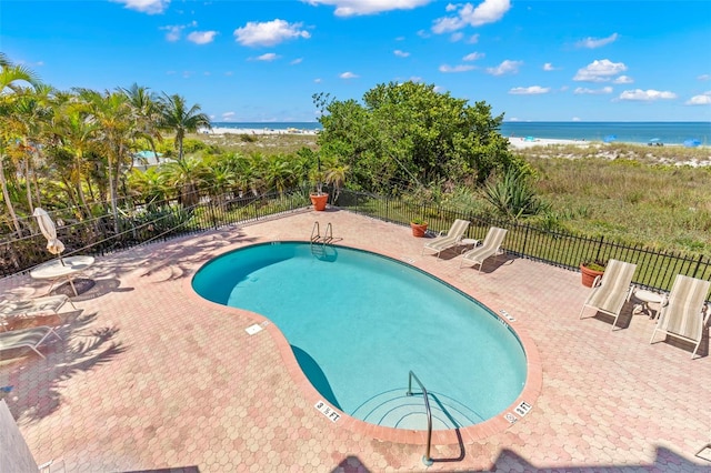 view of pool with a patio and a water view