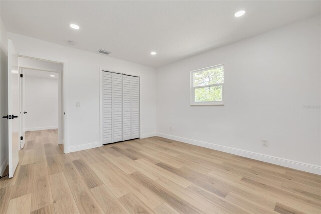 unfurnished bedroom featuring light hardwood / wood-style floors and a closet