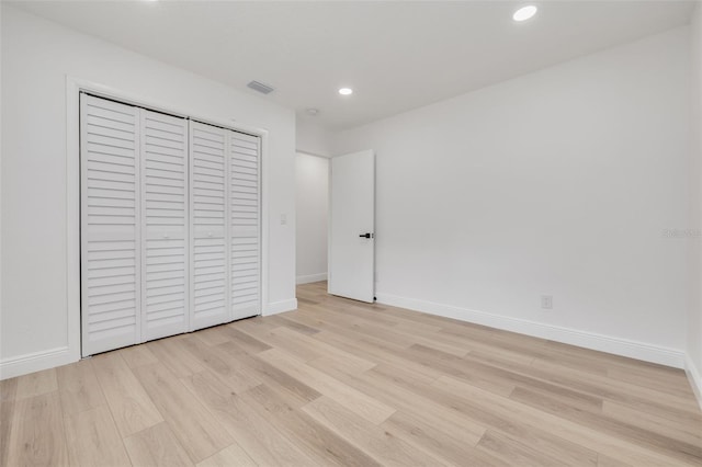 unfurnished bedroom with light hardwood / wood-style floors and a closet