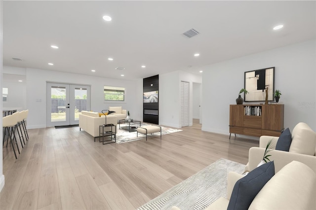 living room with light wood-type flooring and french doors