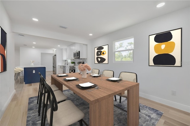 dining area with sink and light hardwood / wood-style flooring