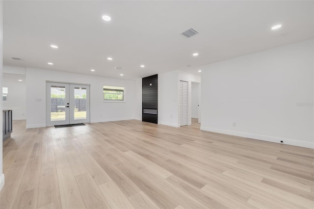 unfurnished living room featuring light hardwood / wood-style flooring and french doors