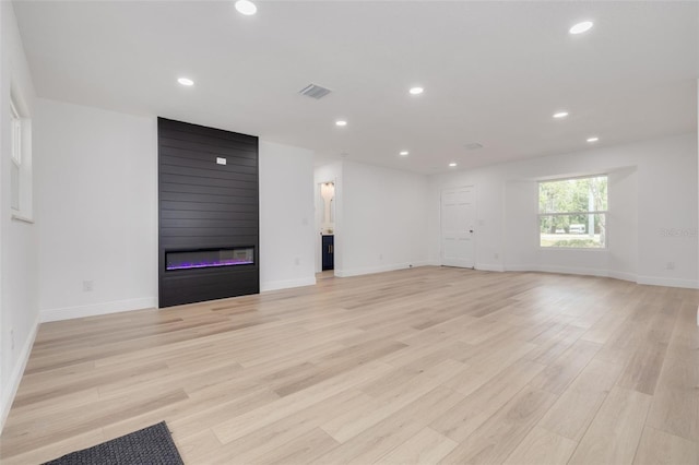 unfurnished living room with a fireplace and light hardwood / wood-style floors