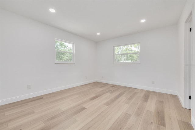 spare room featuring a healthy amount of sunlight and light wood-type flooring