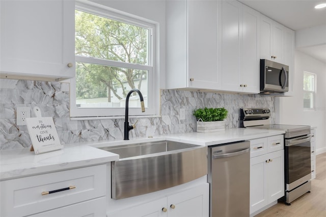 7414 Van Dyke Rd, Odessa, FL 33556 - kitchen featuring stainless steel appliances, a sink, light stone counters, white cabinets, and backsplash