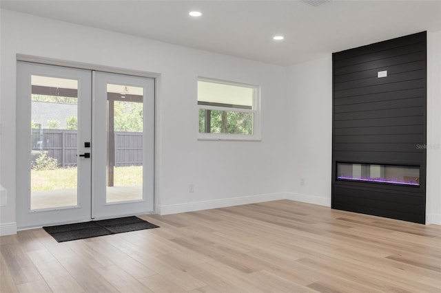 7414 Van Dyke Rd, Odessa, FL 33556 - doorway to outside featuring french doors, a glass covered fireplace, light wood finished floors, baseboards, and recessed lighting