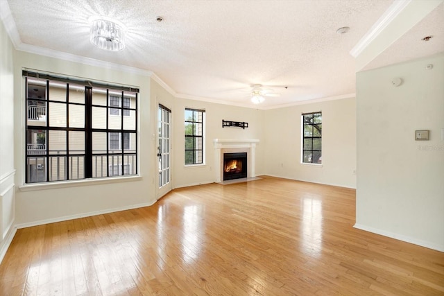 unfurnished living room featuring a textured ceiling, ceiling fan, crown molding, and light wood-type flooring