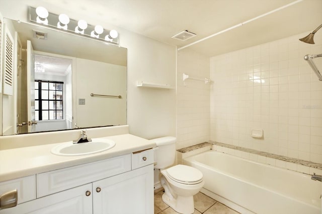 full bathroom featuring tiled shower / bath, vanity, toilet, and tile floors