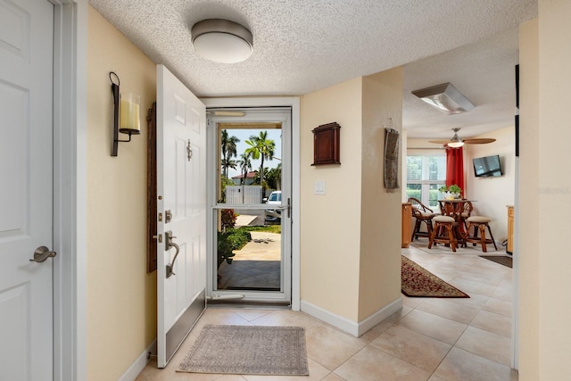 tiled foyer entrance featuring a textured ceiling and ceiling fan