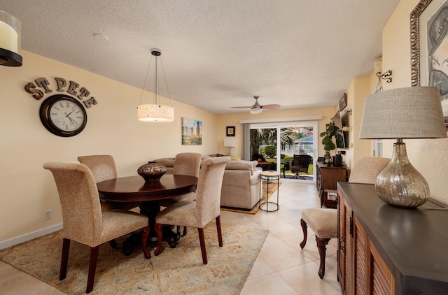 tiled dining room with ceiling fan and a textured ceiling