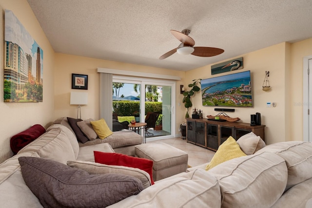 living room featuring tile floors, ceiling fan, and a textured ceiling