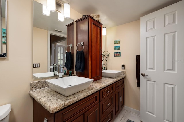 bathroom featuring tile floors, double sink vanity, and toilet