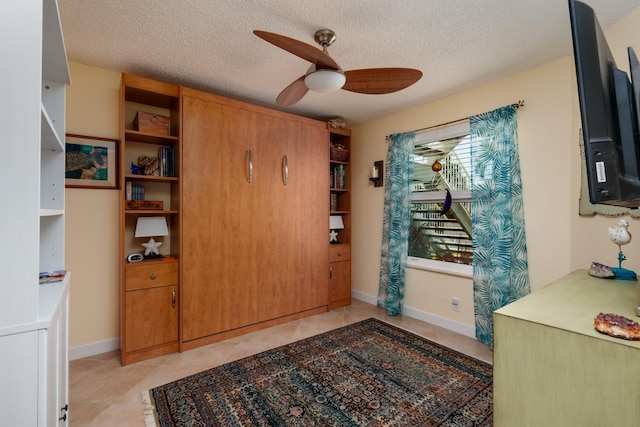 interior space with a textured ceiling and ceiling fan