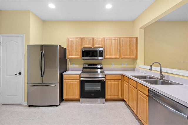 kitchen featuring sink, light tile floors, light brown cabinetry, and appliances with stainless steel finishes