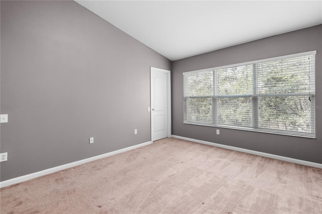 carpeted spare room with lofted ceiling