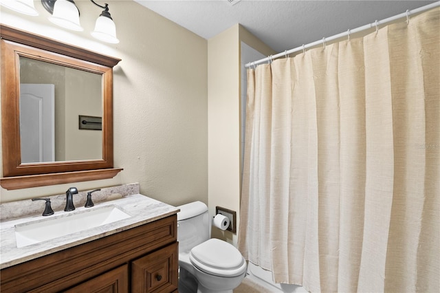 bathroom featuring a textured ceiling, toilet, and vanity