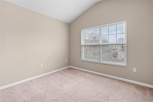 carpeted spare room featuring lofted ceiling