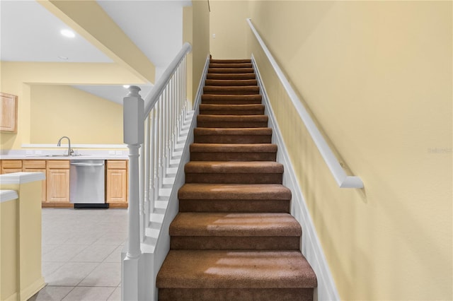 stairway featuring sink and light tile flooring