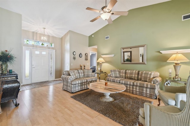 living room with ceiling fan, high vaulted ceiling, and light wood-type flooring